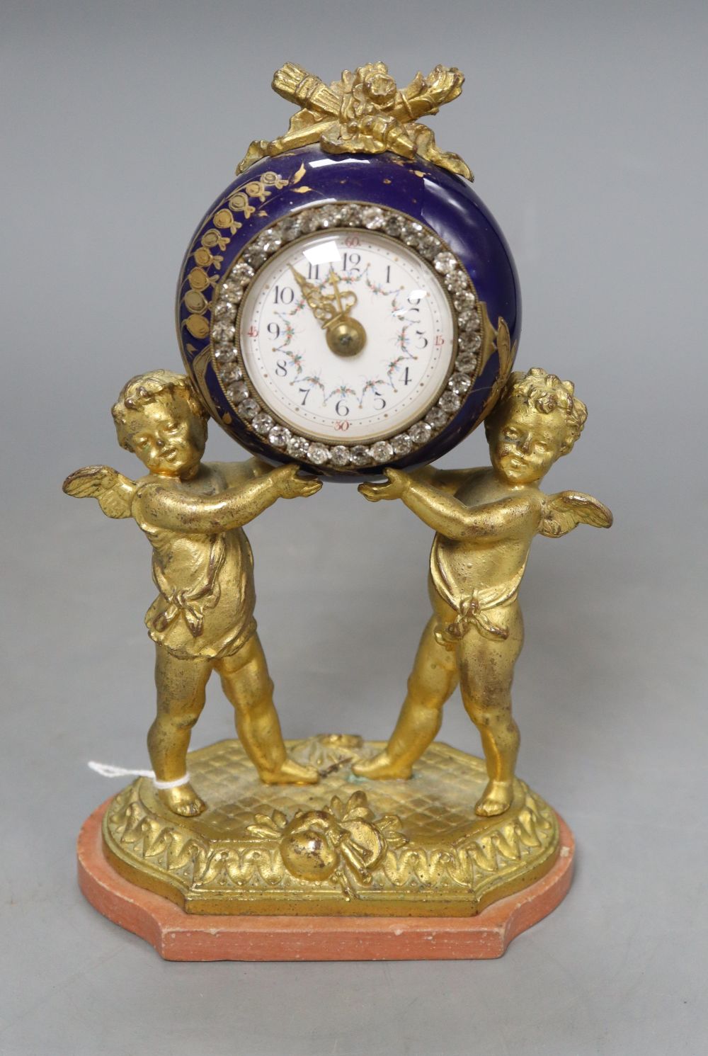 A French gilt metal and enamel cherub timepiece, height 18.5cm